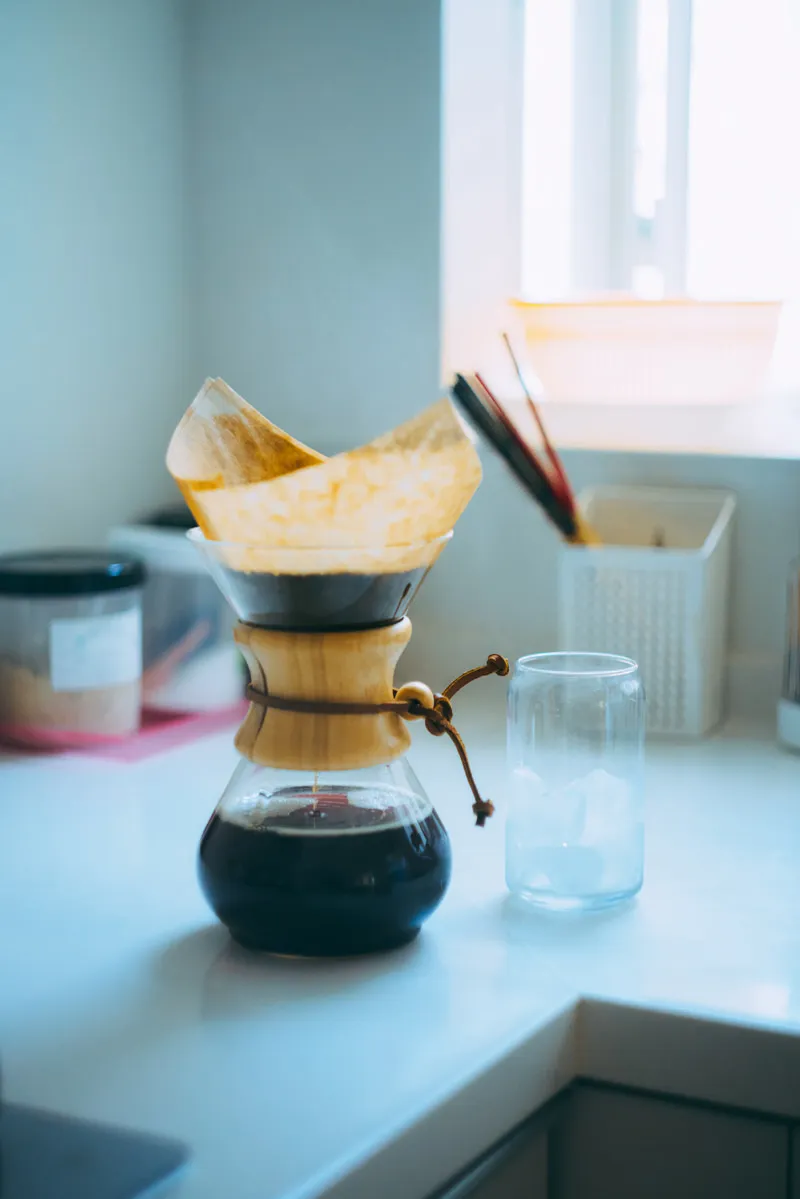 窓辺のカウンターで、コーヒーをドリップしているところ