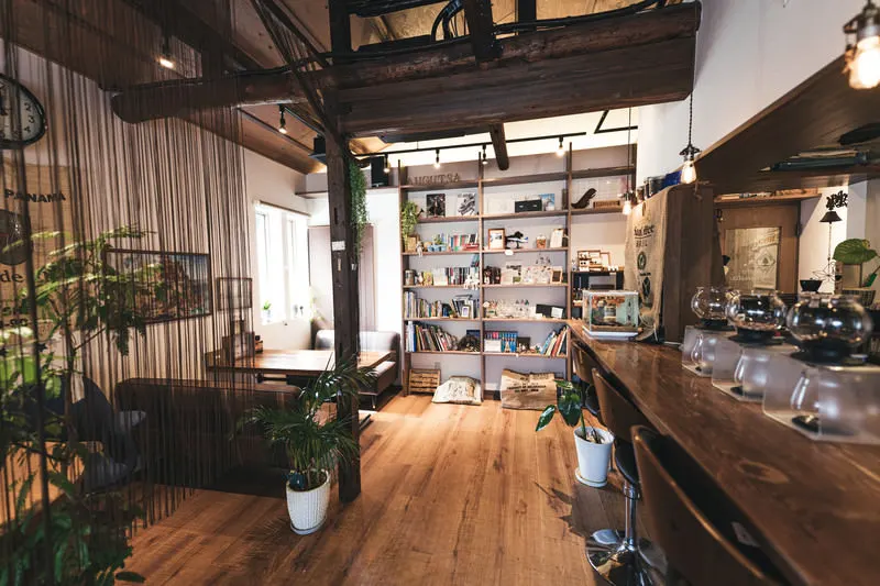 木の床と棚がある、明るい喫茶店の店内